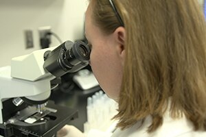 Scientist looking through microscope