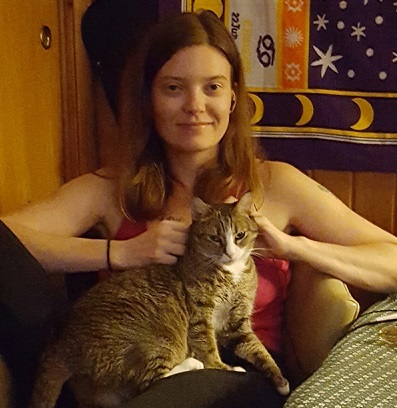 Woman in pink shirt sitting with a cat on her lap