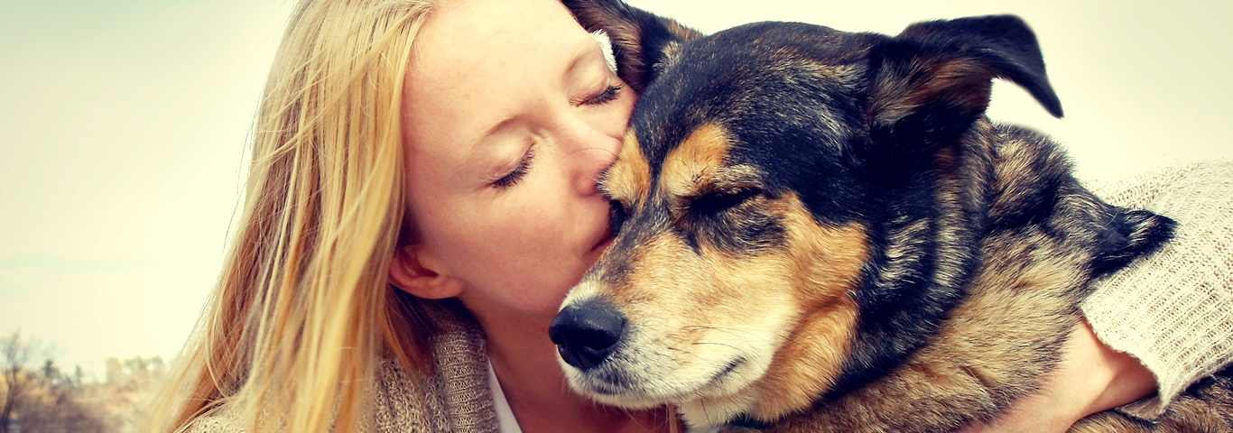 Woman Tenderly Hugging And Kissing Pet Dog
