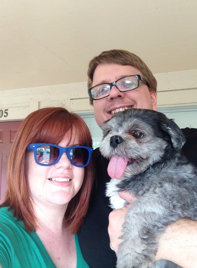 Man and woman pose for picture holding their shih tzu